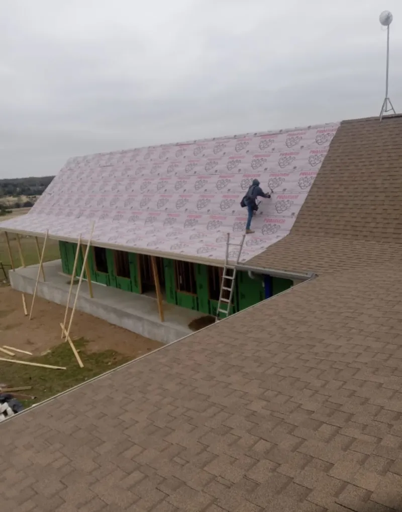 Worker preparing underlayment for a metal roof installation in Lake Mary